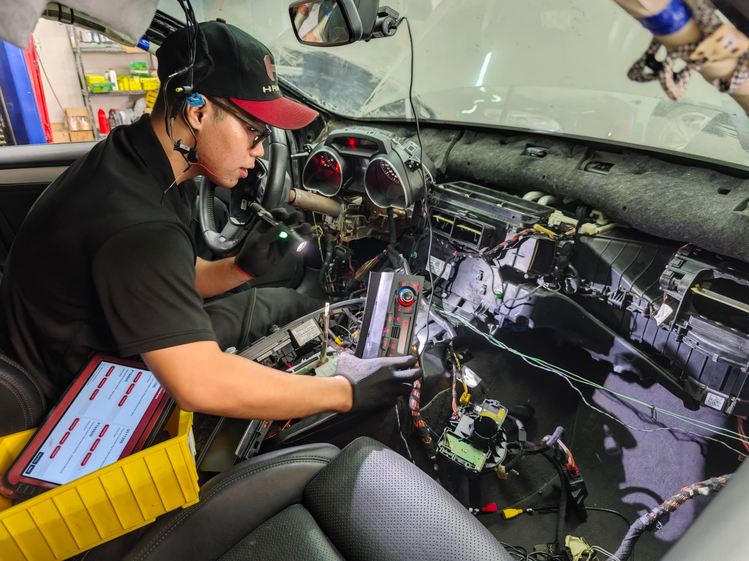 Tú Nguyễn — kỹ sư điện & chẩn đoán BMAP Workshop đang dò hệ thống điện sau taplo một chiếc xe Đức
