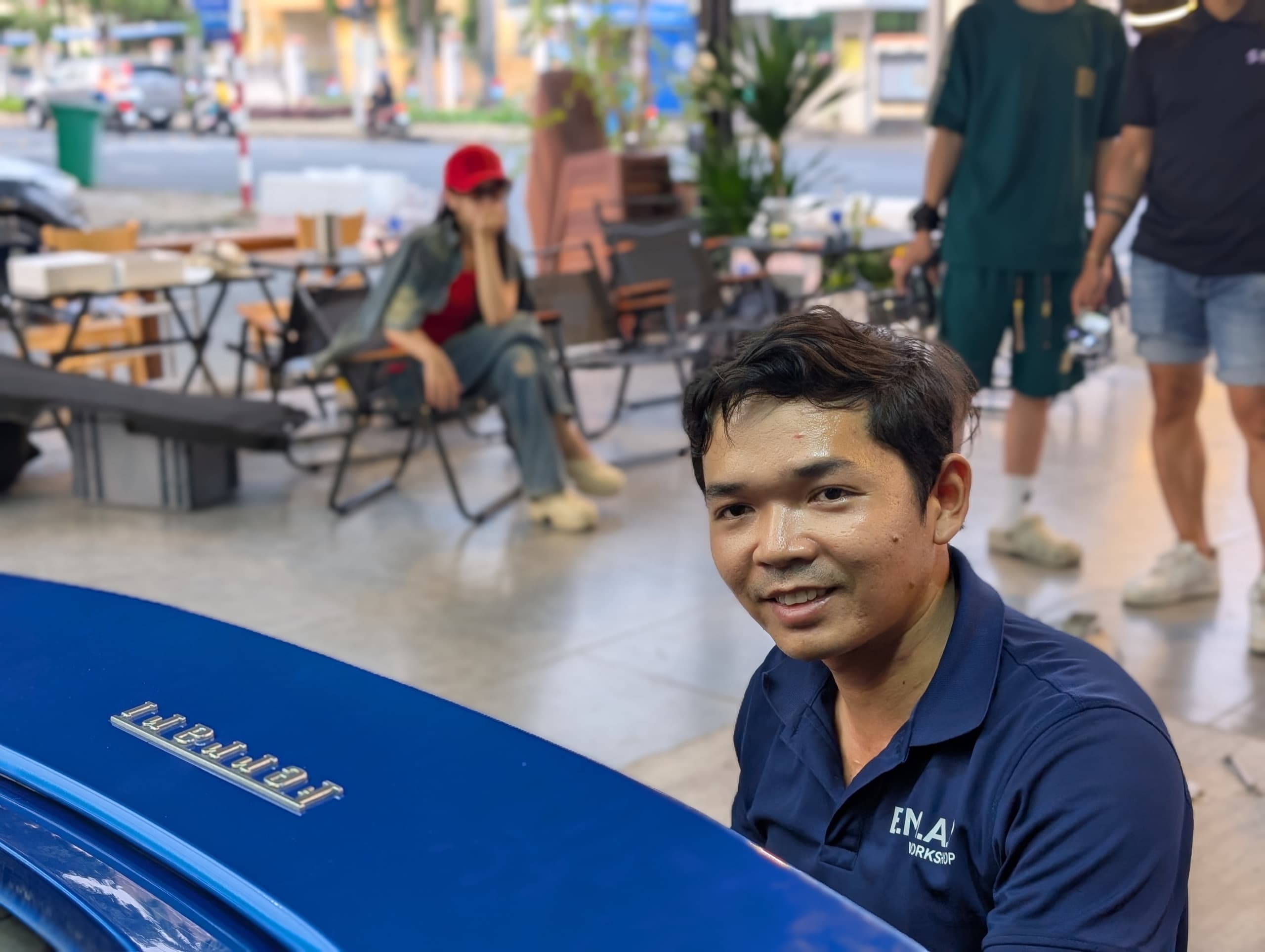 Cảnh Lê — Quản lý & Cố vấn dịch vụ BMAP Workshop, bên chiếc Ferrari xanh tại xưởng